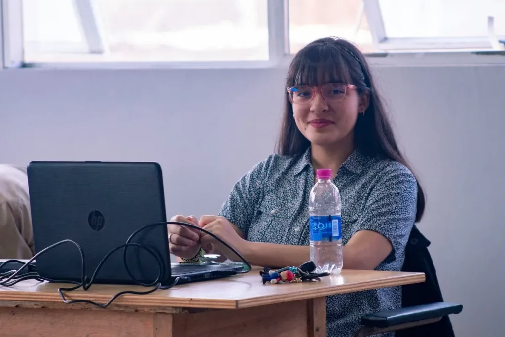 Mulher sentada à mesa com notebook em curso gratuito de informática