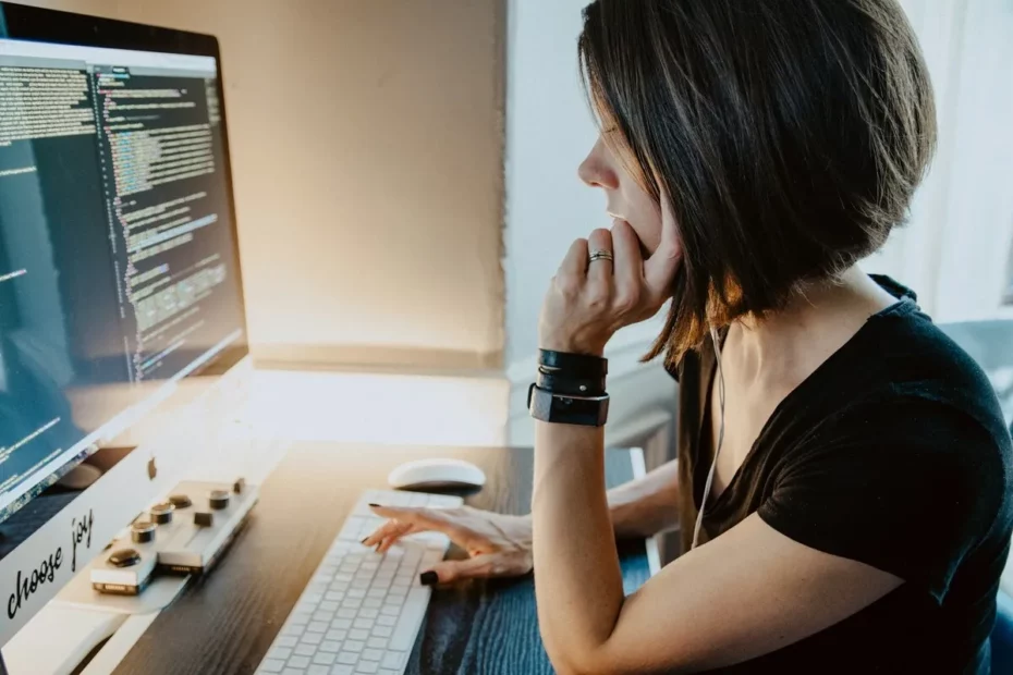 Mulher digitando código em computador durante curso de programação