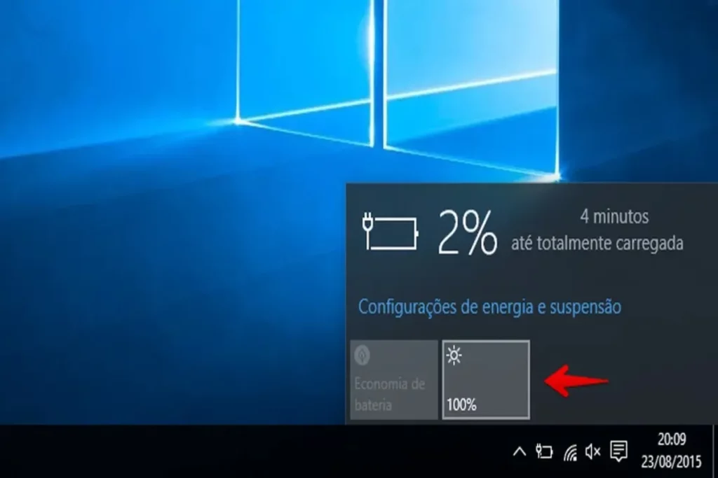 Como diminuir o brilho da tela do Windows 10, mostrando o ícone de brilho em 100% na barra de tarefas, com a porcentagem da bateria em 2% e um indicador de carregamento.