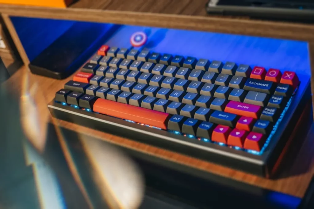 Teclado mecânico customizado com teclas cinzas, laranjas e vermelhas, destacando os switches de teclado RGB.