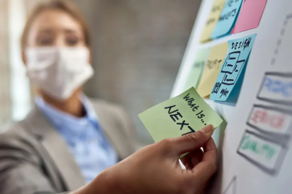 Mulher mexendo em quadro com post-its