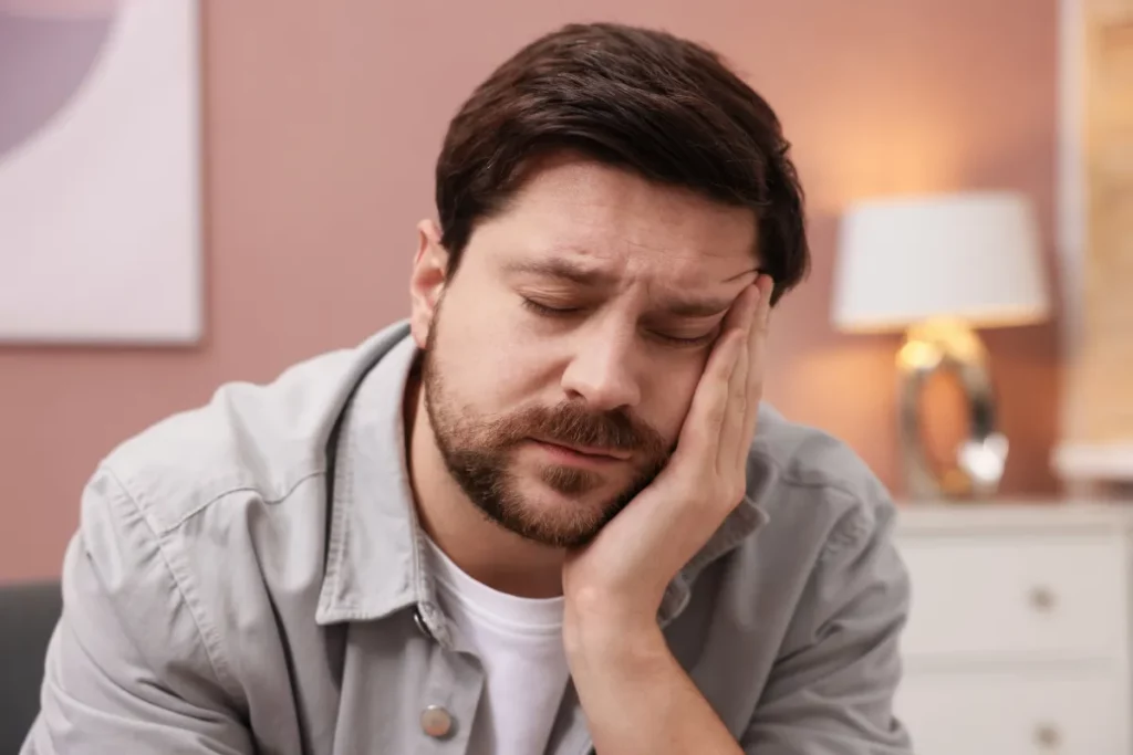 Homem com a cabeça apoiada na mão