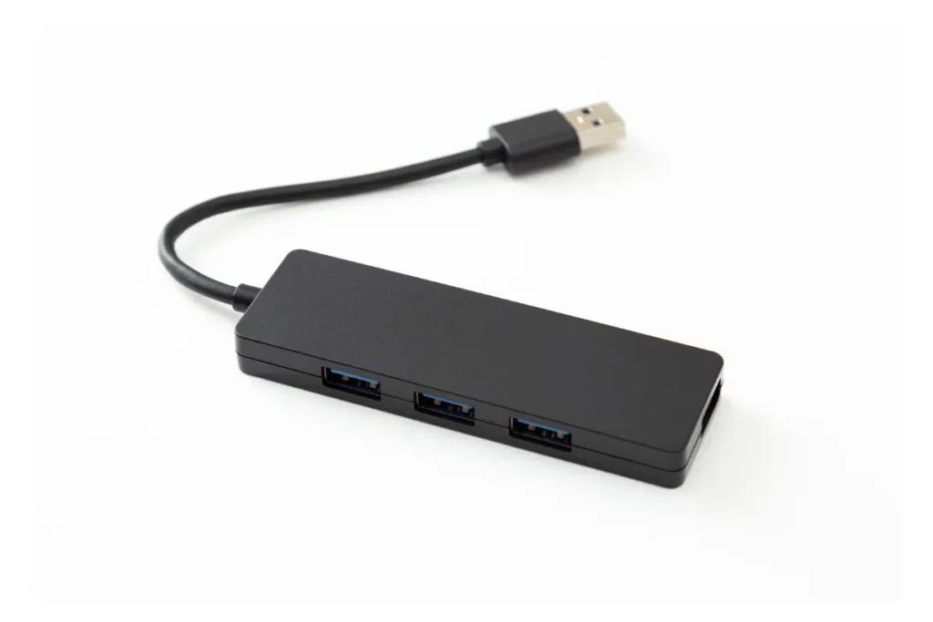 hub usb preto com cabo integrado e três portas usb alinhadas sobre fundo claro
