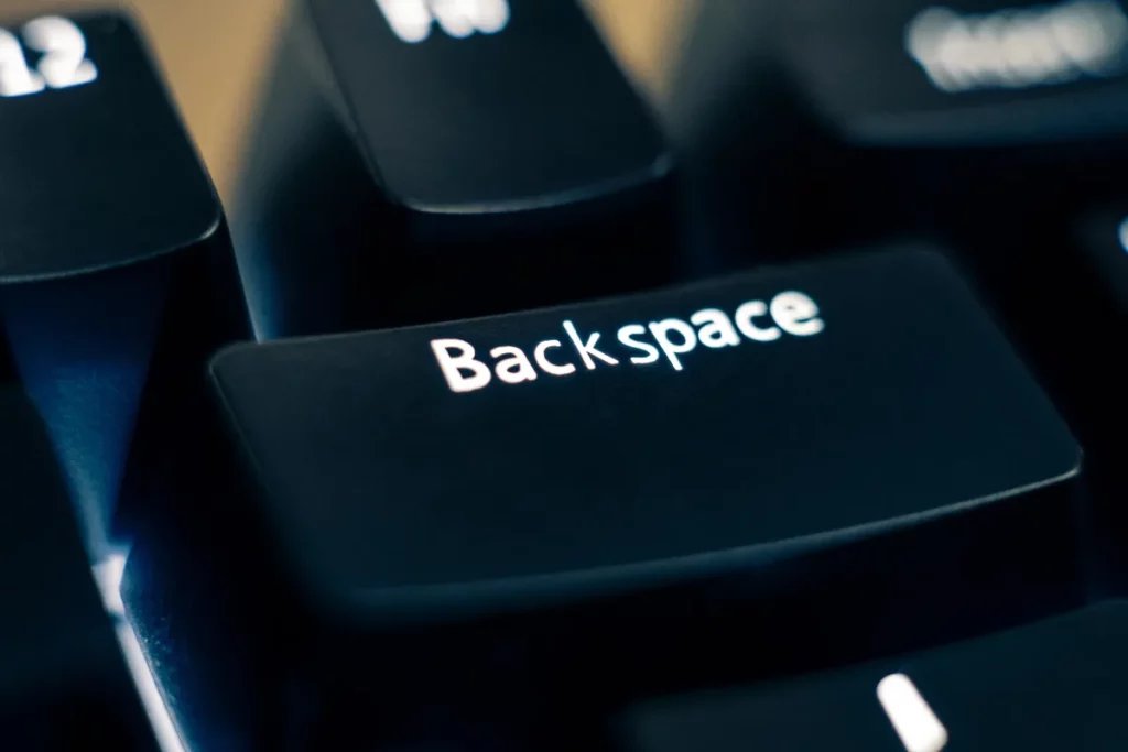 tecla backspace em teclado preto com iluminação suave ao redor